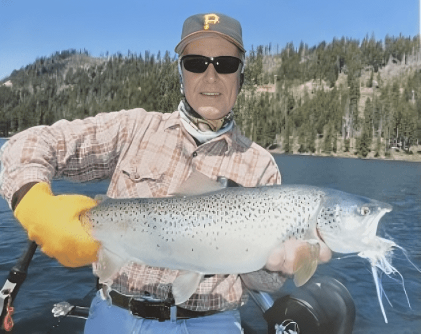Man holding a large fish on boat.
