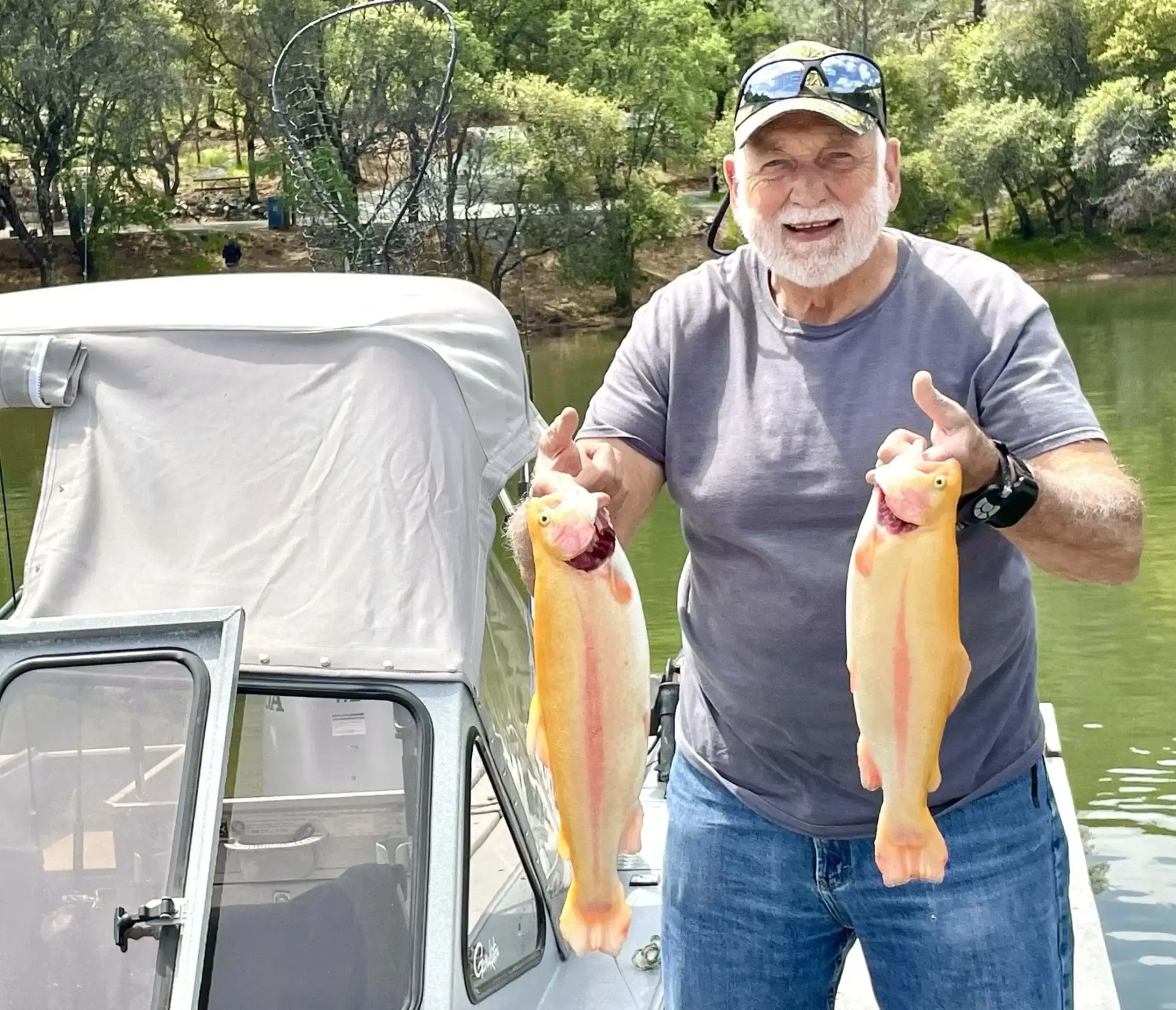 Smiling bearded man holding two fish