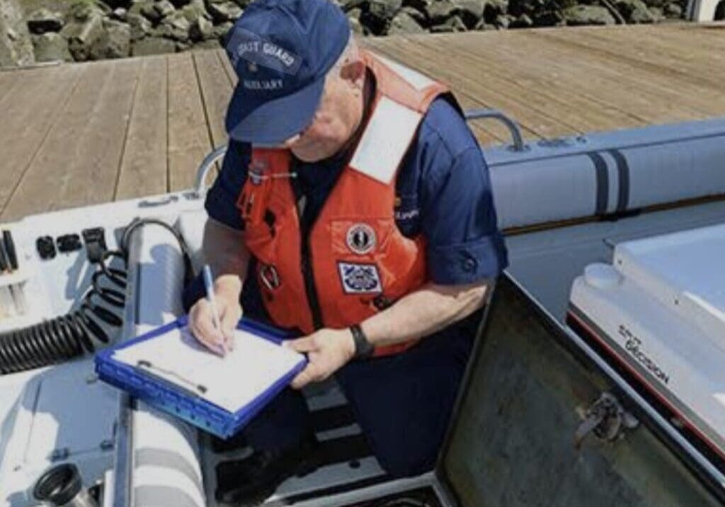 A man in uniform writing on a clipboard on a boat.